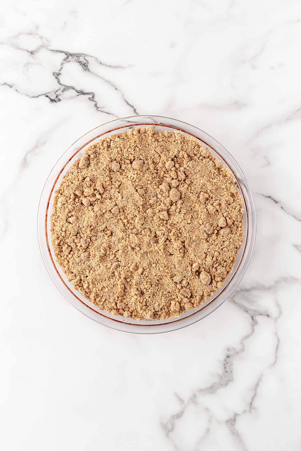 Glass pie dish filled with brown sugar crumble topping