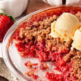 Strawberry crumble topped with a scoop of vanilla ice cream
