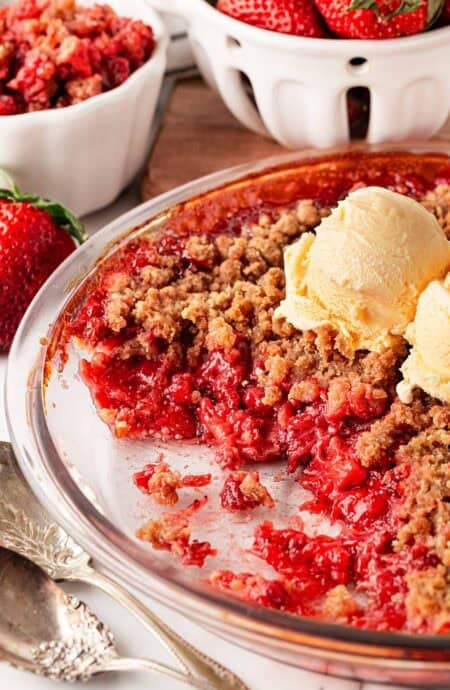 Strawberry crumble topped with a scoop of vanilla ice cream