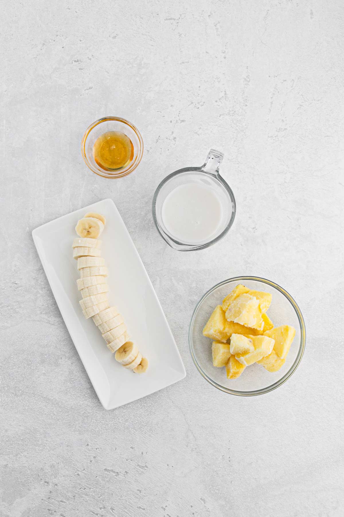 Ingredients for a pina colada smoothie recipe on the table.