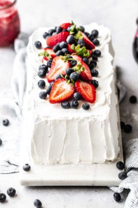 Close up shot of Whipped cream topped Icebox Cake recipe garnished with strawberries and blueberries