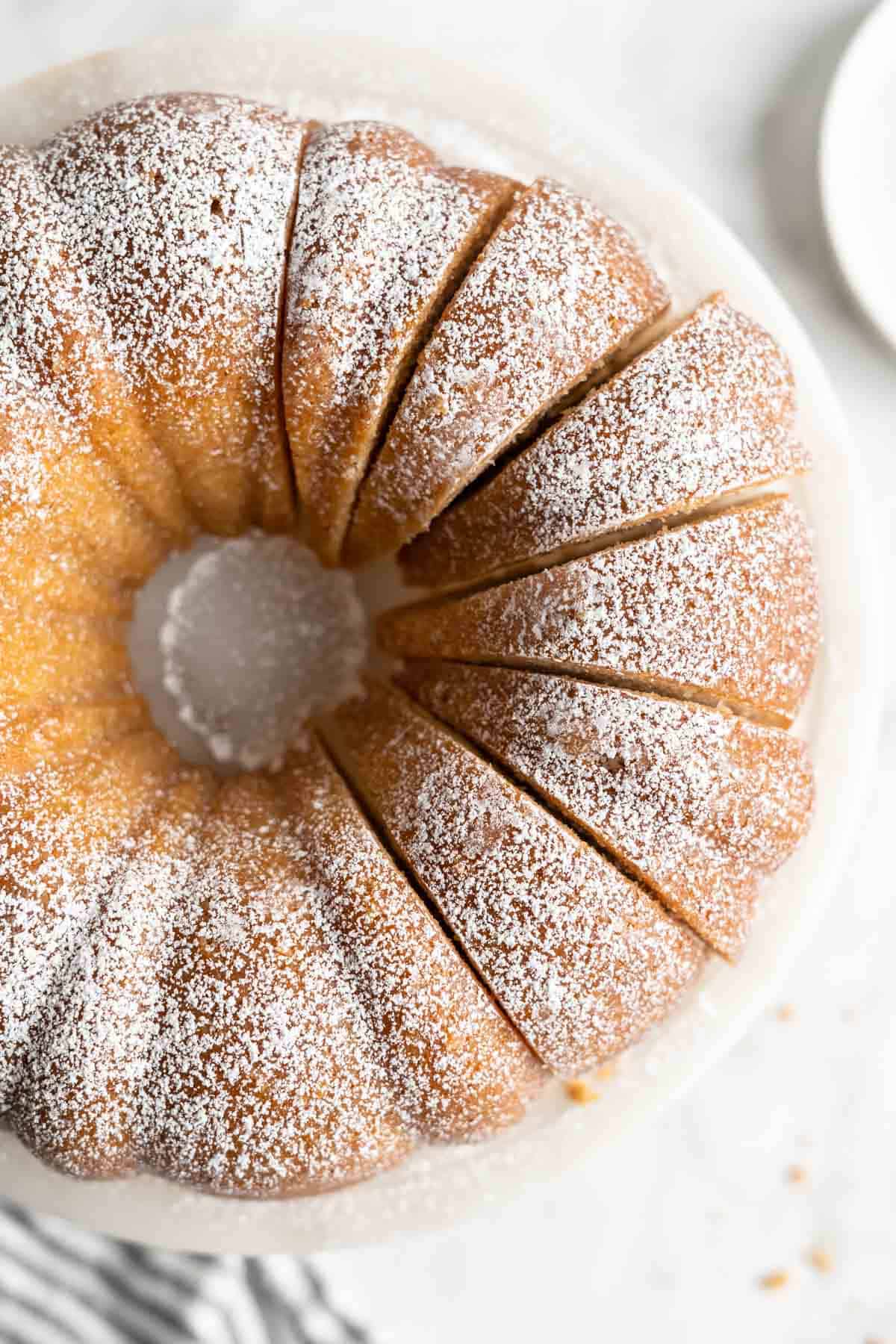 Overhead image of brown butter pound cake with slices cut on a cake stand.