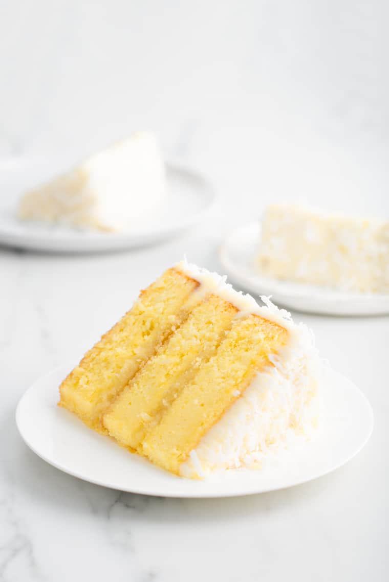 Close up of three slices of Pineapple Coconut Cake recipe on white plates