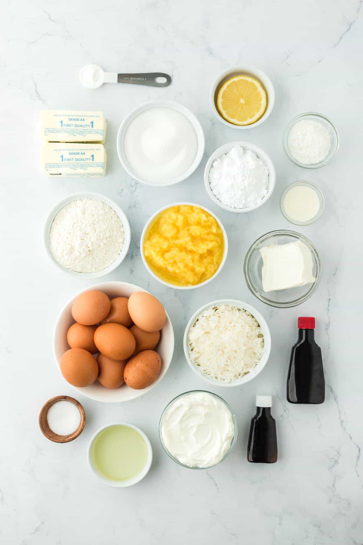 Overhead shot of the ingredients for making pineapple coconut cake on a marble surface before baking