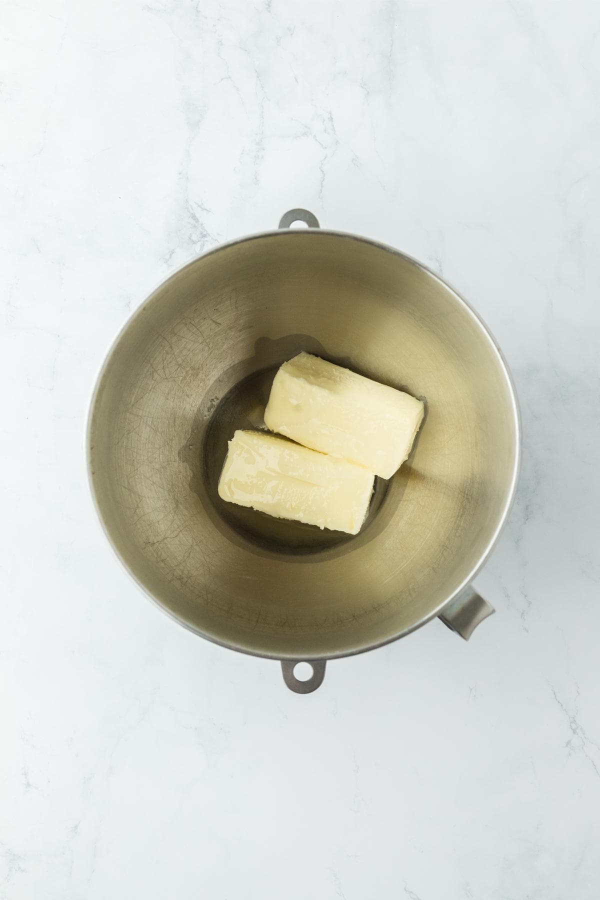 Two sticks of butter in a stainless steel mixing bowl, ready for creaming