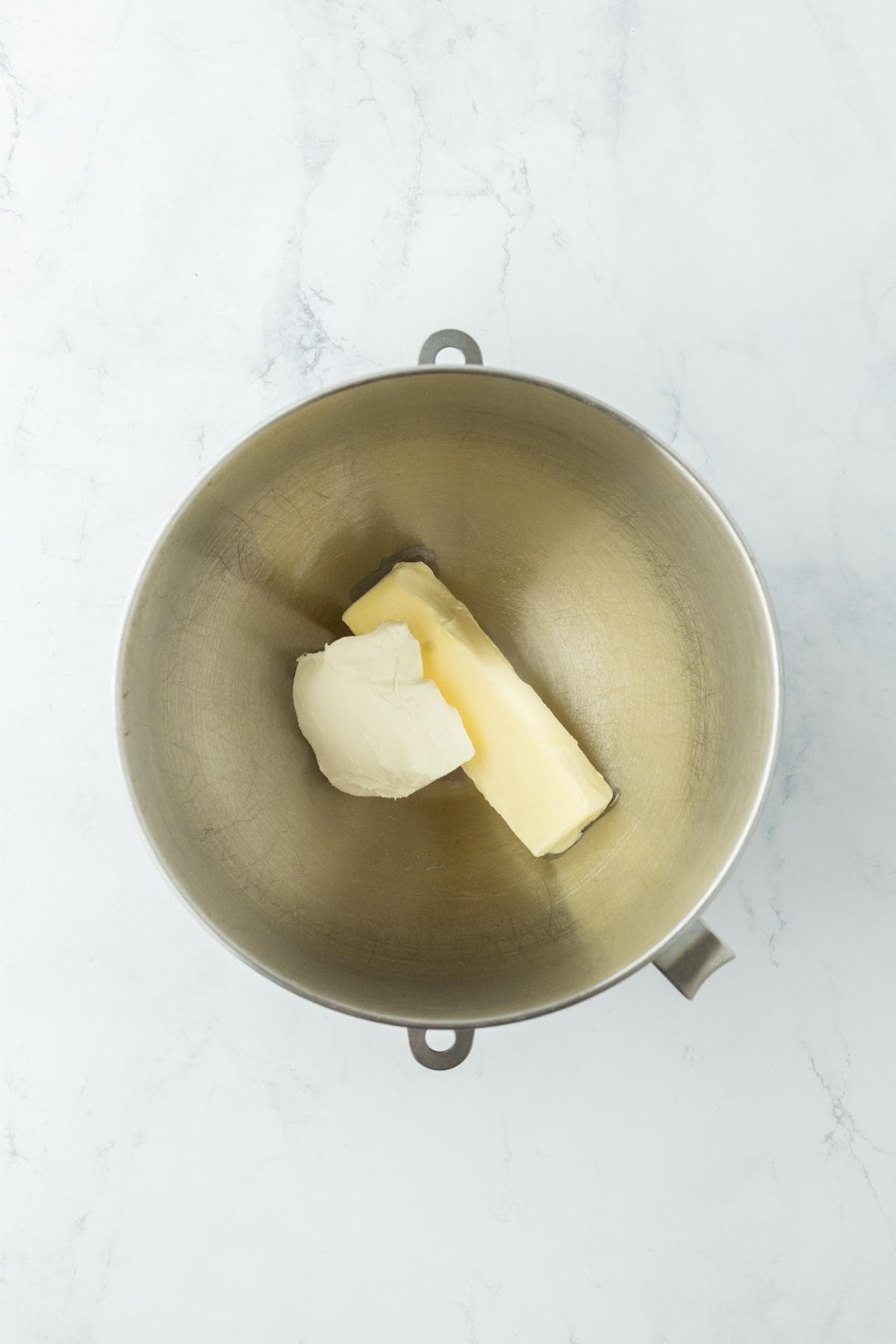 Butter and cream cheese in a mixing bowl, ready to be combined