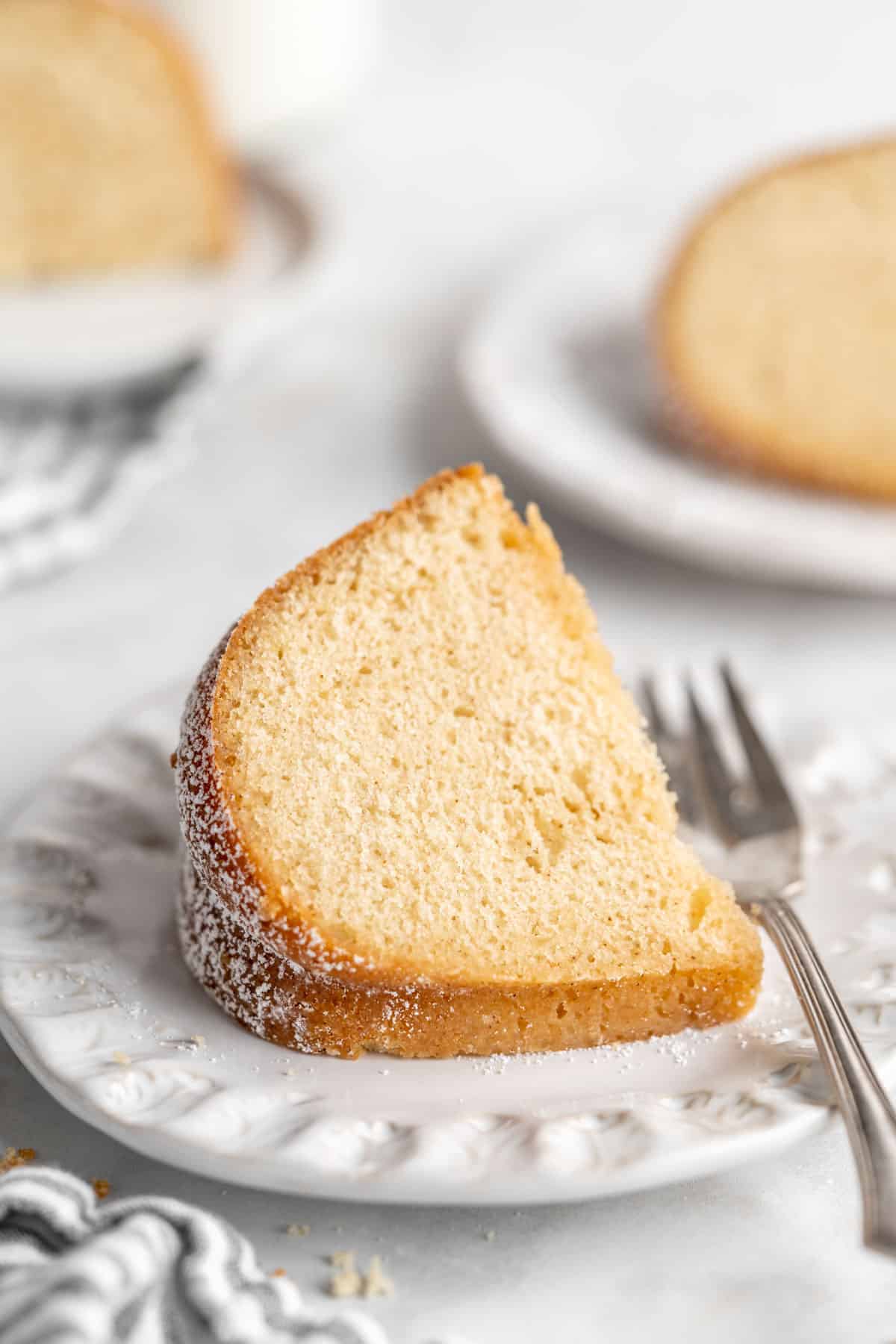 A slice of Kentucky butter cake on a plate with a fork to the side.