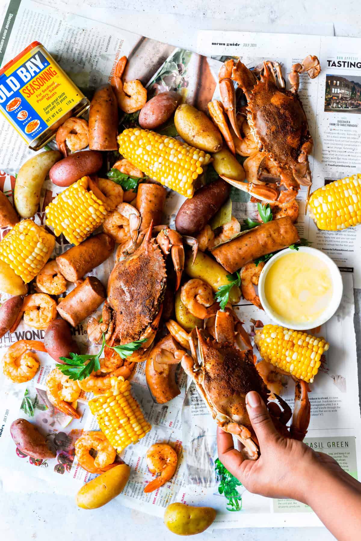 Overhead shot of hand picking up blue crab at low country boil gathering