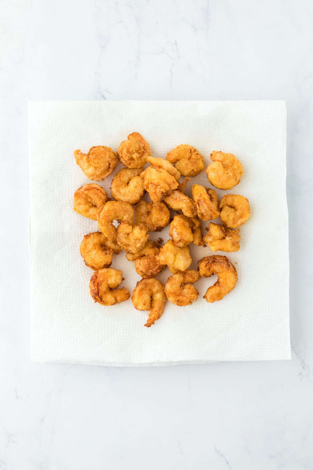 Fried shrimp draining on paper towels