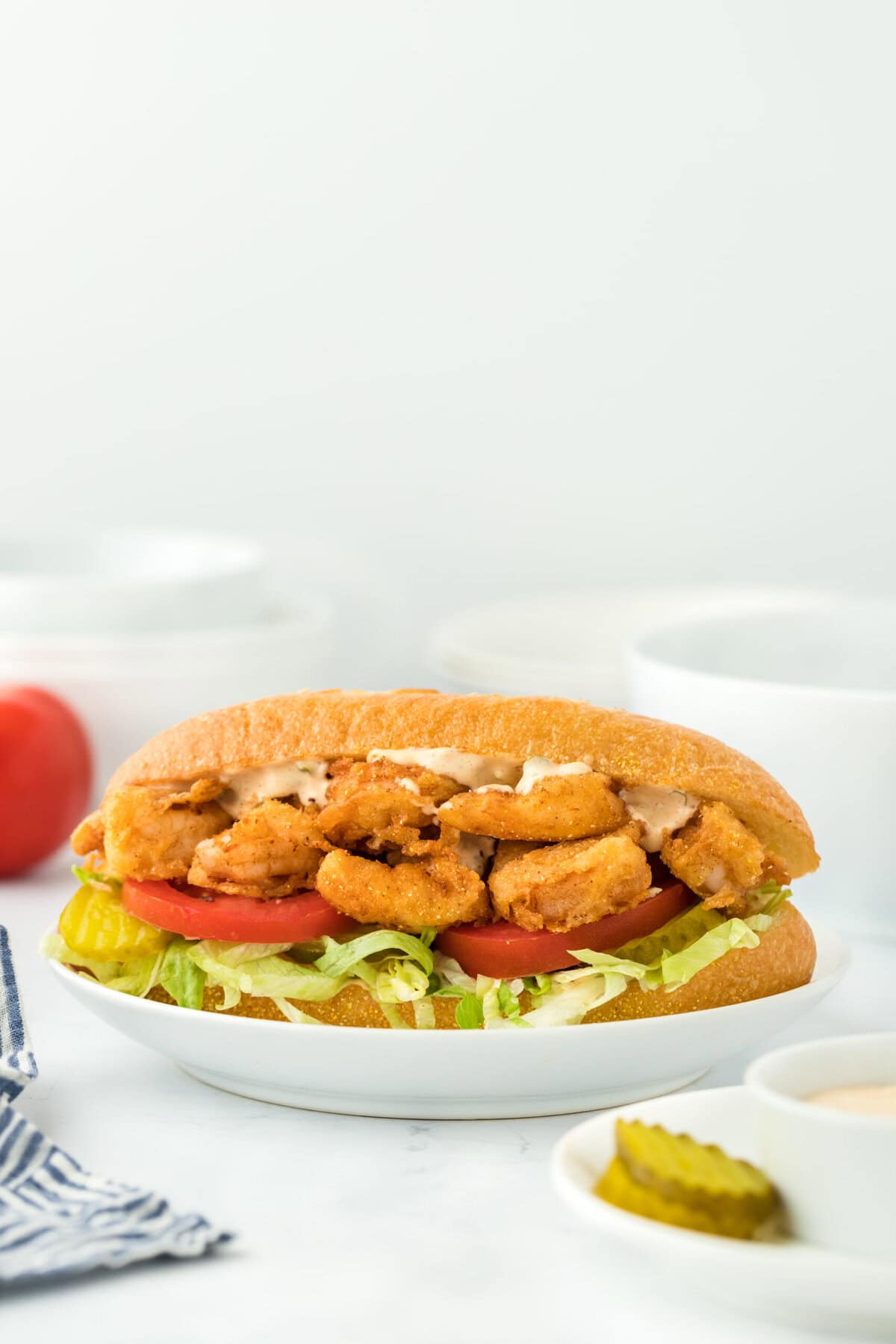 Fried shrimp po boy on a white plate in the white background ready to serve