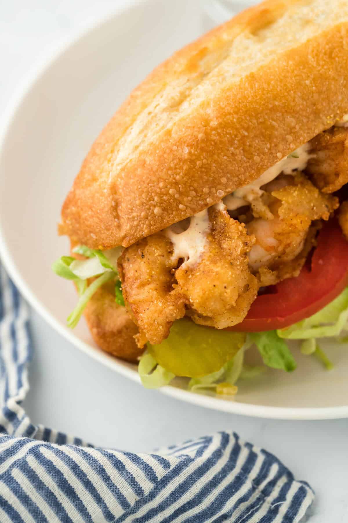 A shrimp po'boy ready to enjoy closed up and dressed and ready to serve