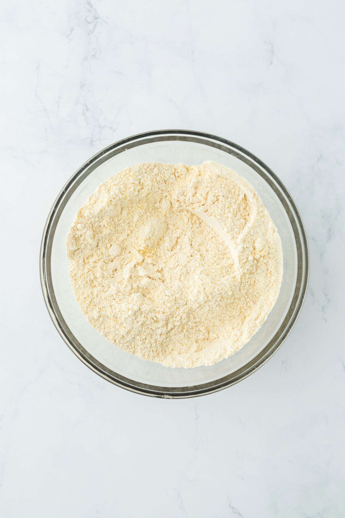 Cornmeal fry mixture in a glass bowl on white countertop