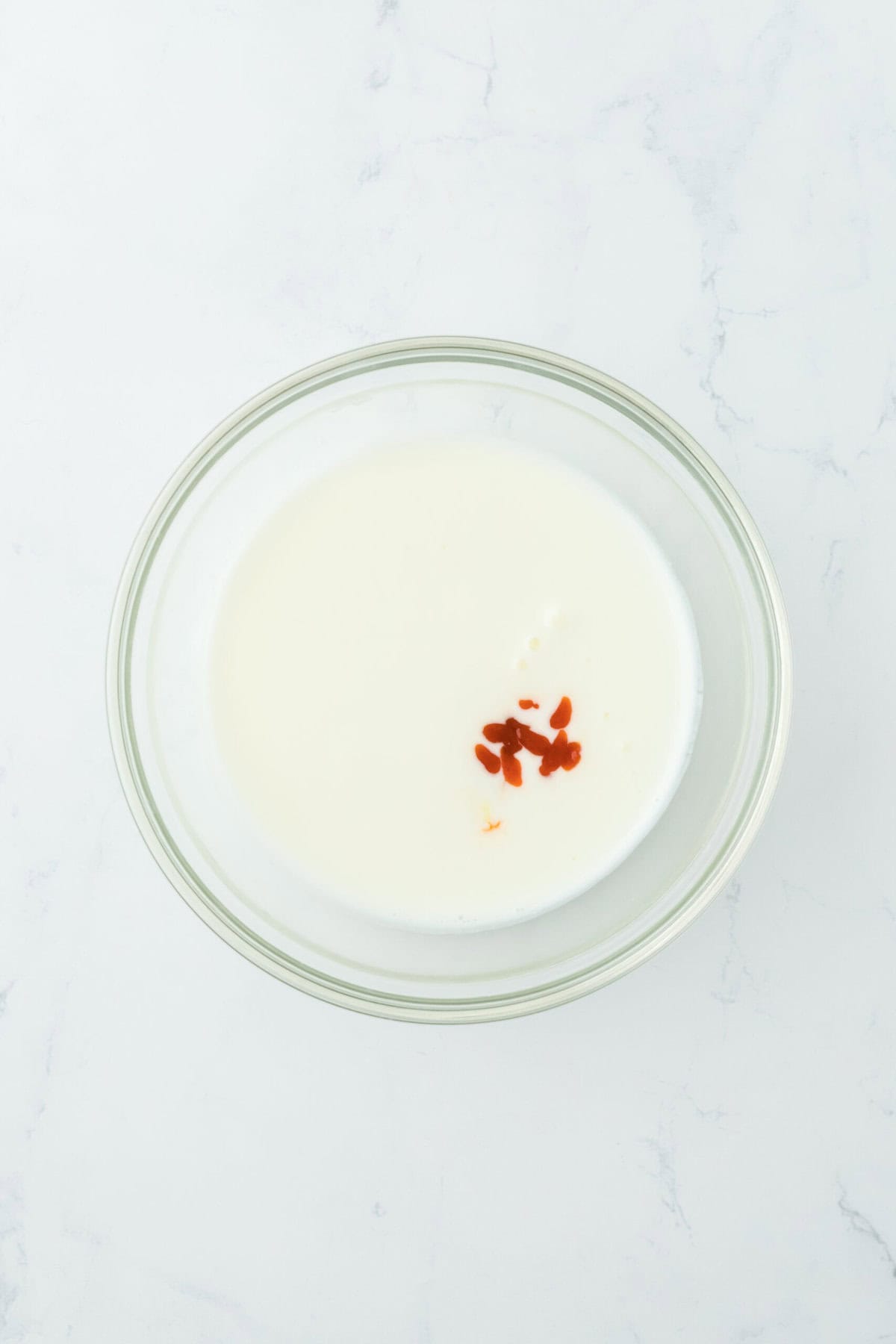 Buttermilk and hot sauce in a glass bowl