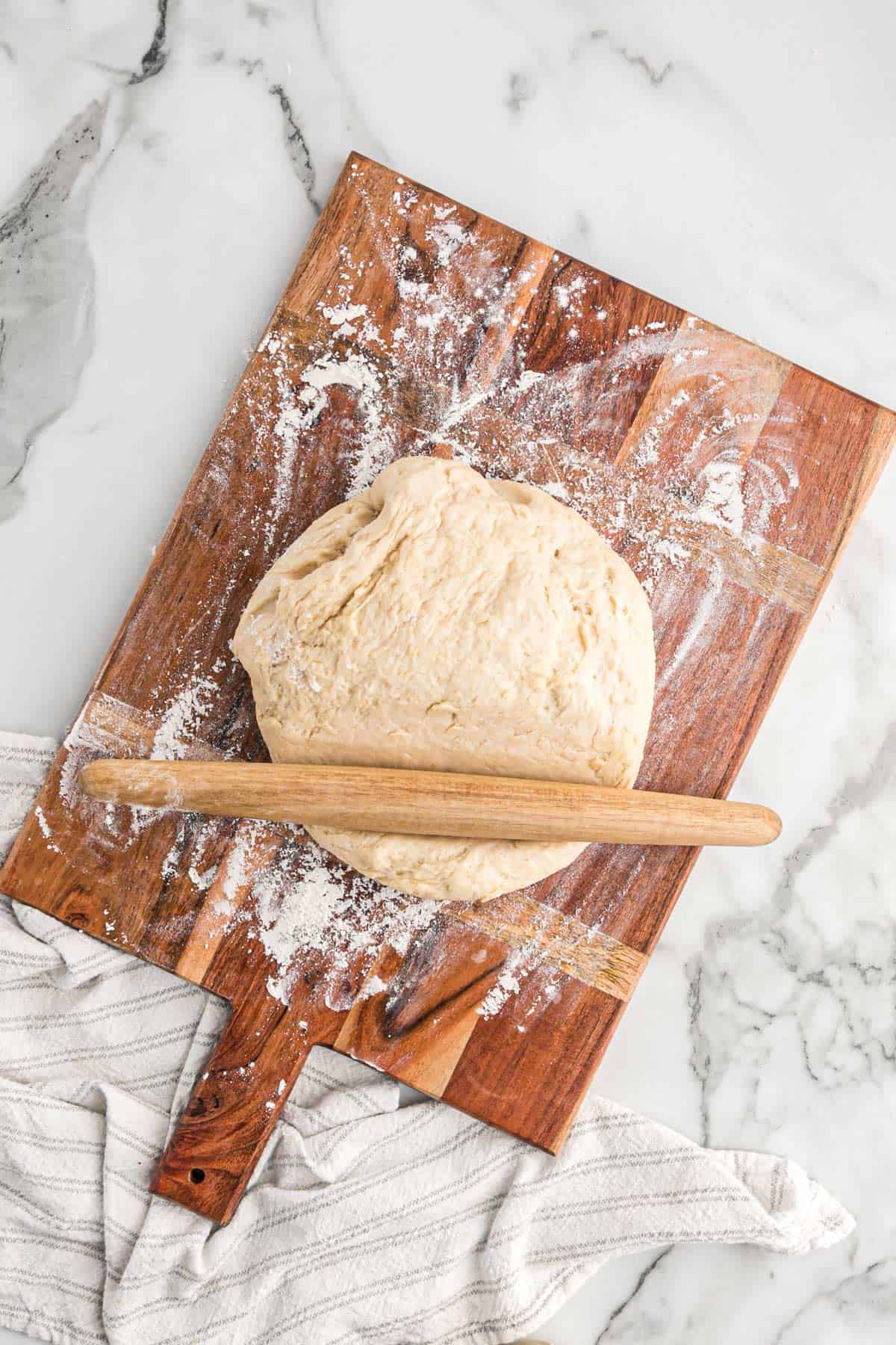 Dough on a well floured surface with a rolling pin.
