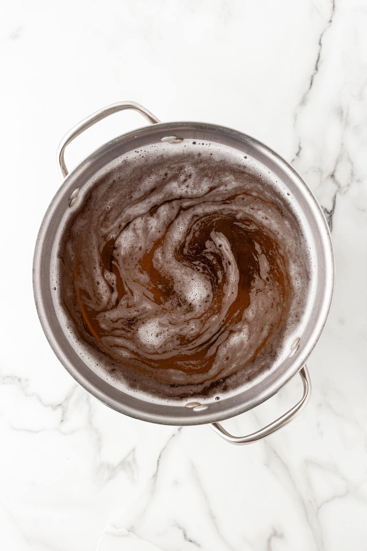 Seasoned seafood boil broth swirling in a large stockpot before adding ingredients