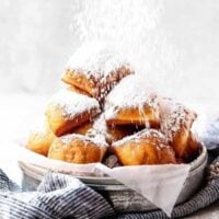 A basket of New Orleans beignets with powdered sugar.