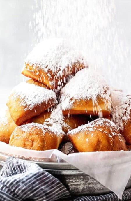 A basket of New Orleans beignets with powdered sugar.