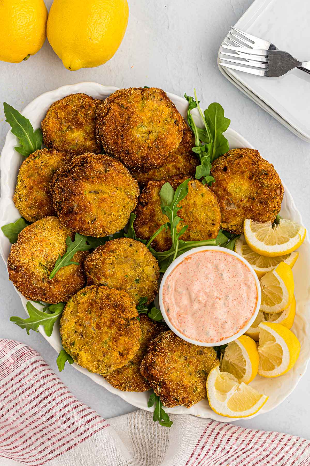 Overhead of salmon croquettes or salmon cakes on white platter with tartar sauce