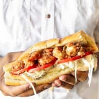 Close up photo of hands holding a New Orleans Shrimp Po' Boy