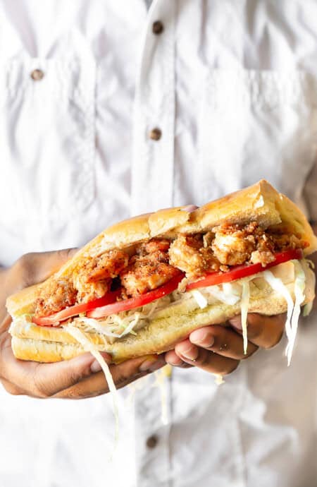 Close up photo of hands holding a New Orleans Shrimp Po' Boy
