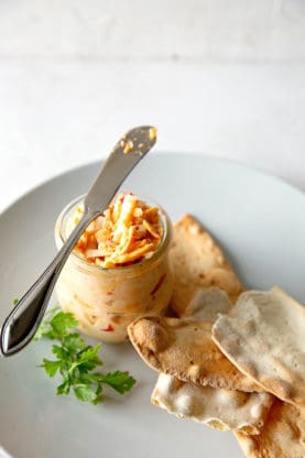 Pimento cheese ready to spread on crackers against white background