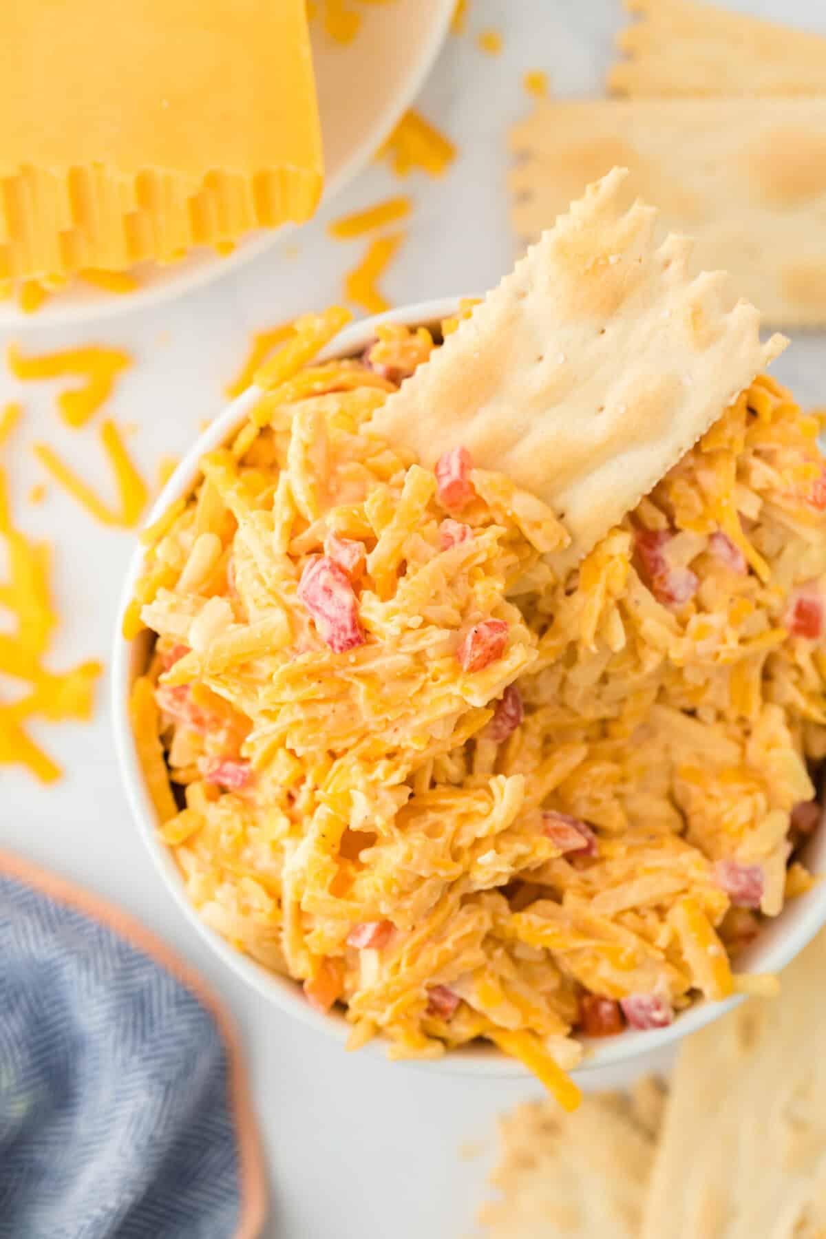 A cracker inside the best Southern pimento cheese recipe with cheese in the white background