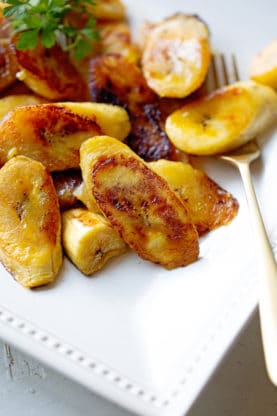 A close up of fried plantains on a white plate