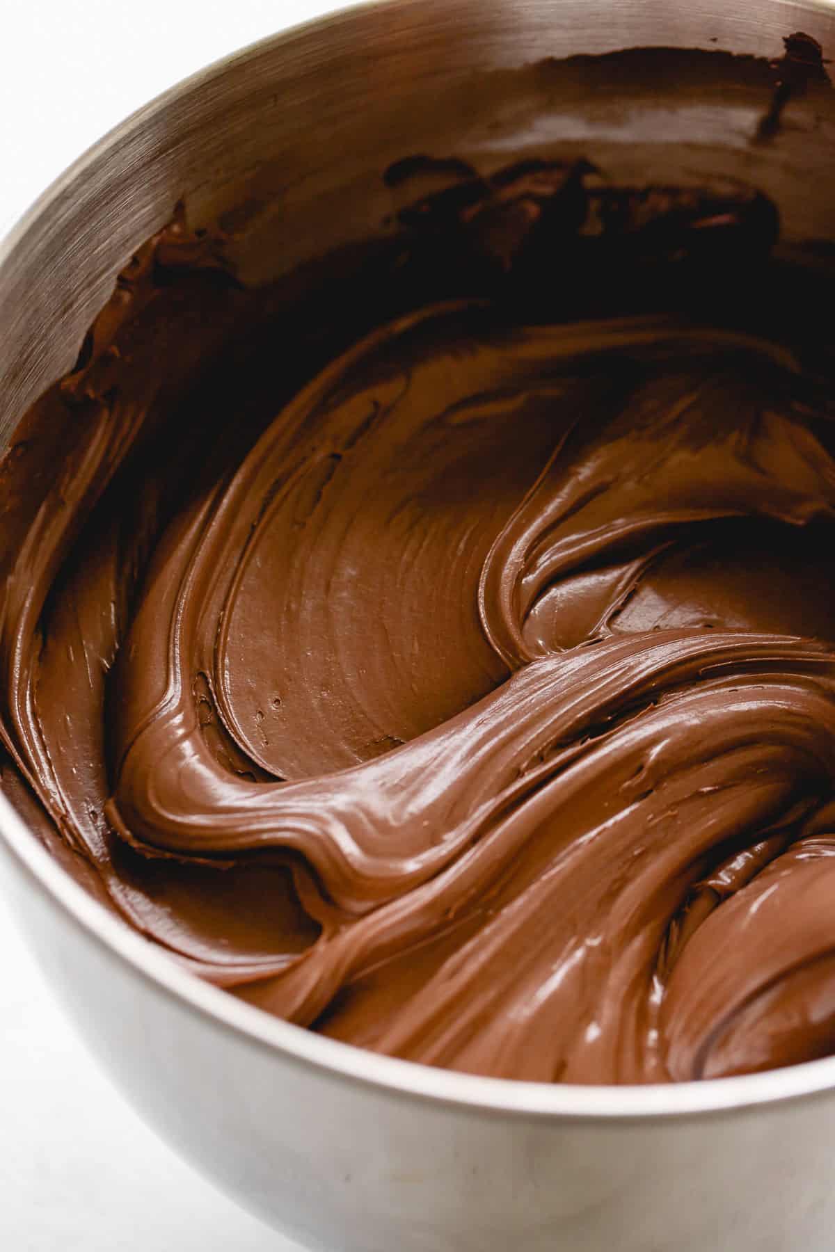 Glossy chocolate buttercream in a mixer bowl.