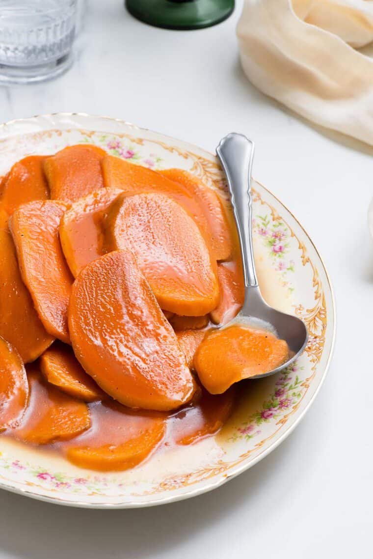 A platter of Candied Sweet Potatoes recipe with spoon