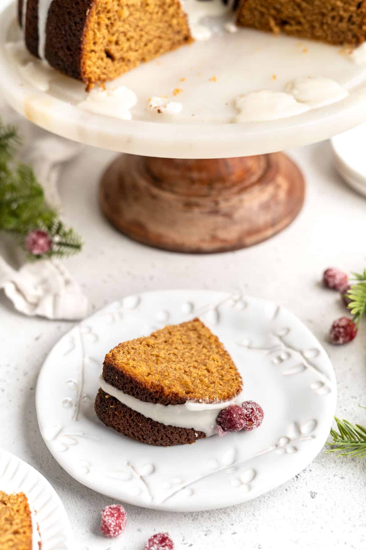 A slice of gingerbread bundt cake on white plate.