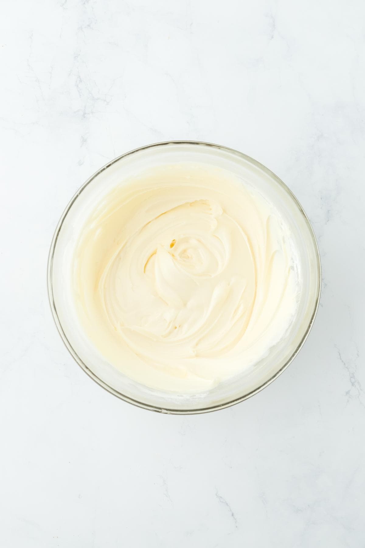 Frosting mixed to a creamy consistency in a glass bowl