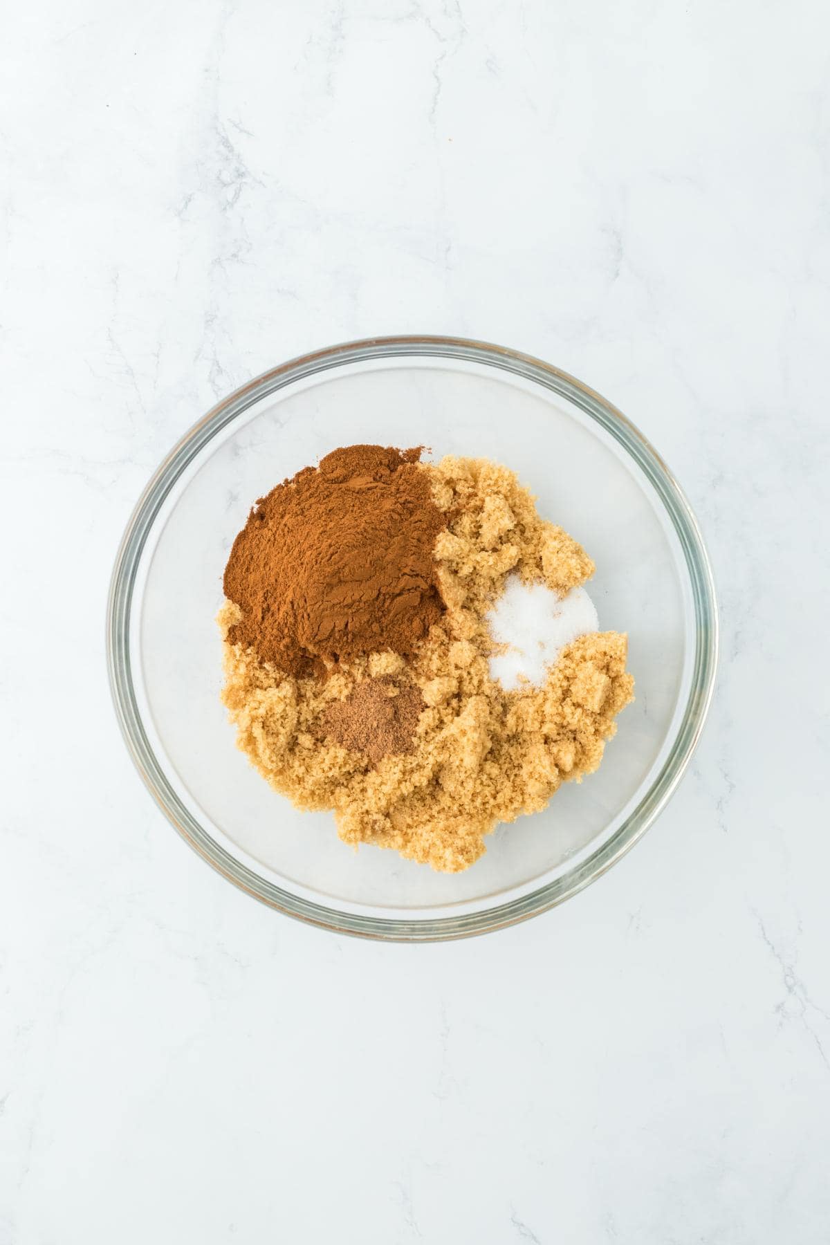 A mixing bowl with brown sugar, cinnamon, and spices for the filling