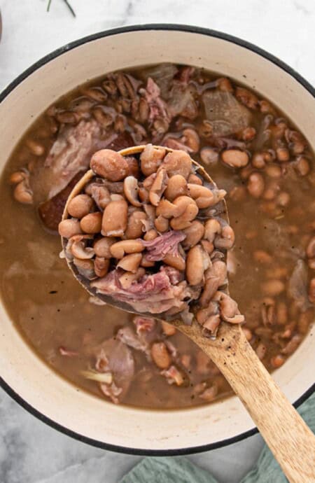 A big bowl of pinto beans with a spoon ready to eat