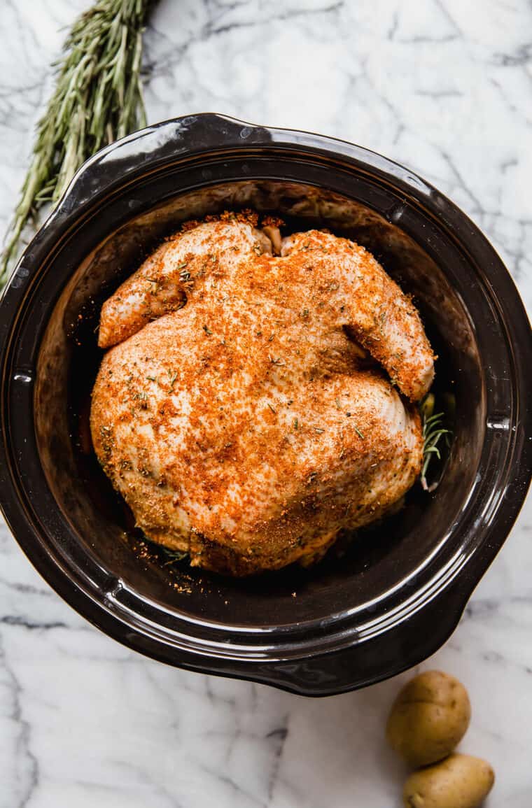 Seasoned rosemary chicken inside slow cooker before cooking