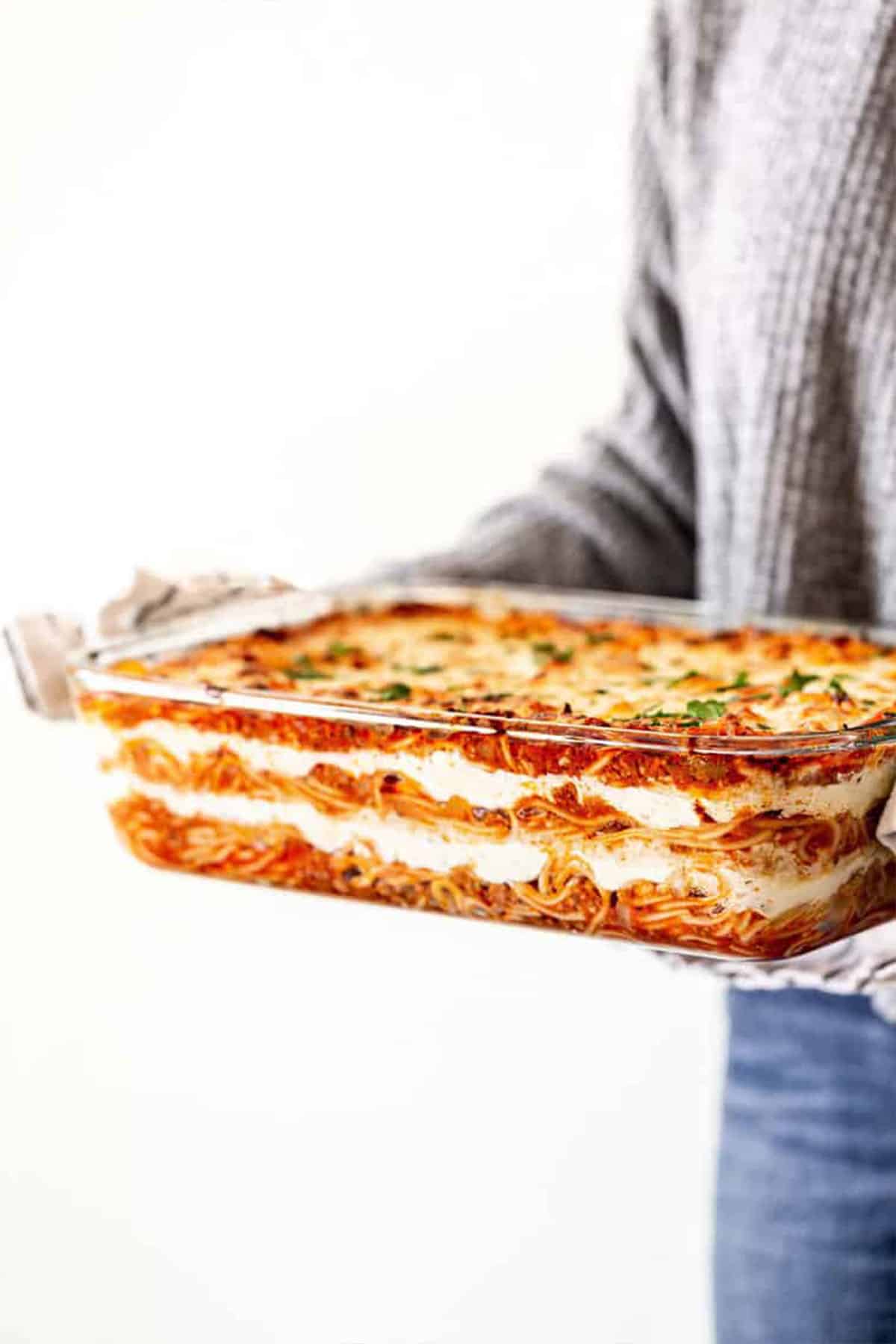 Woman holding delicious baked spaghetti recipe in hands