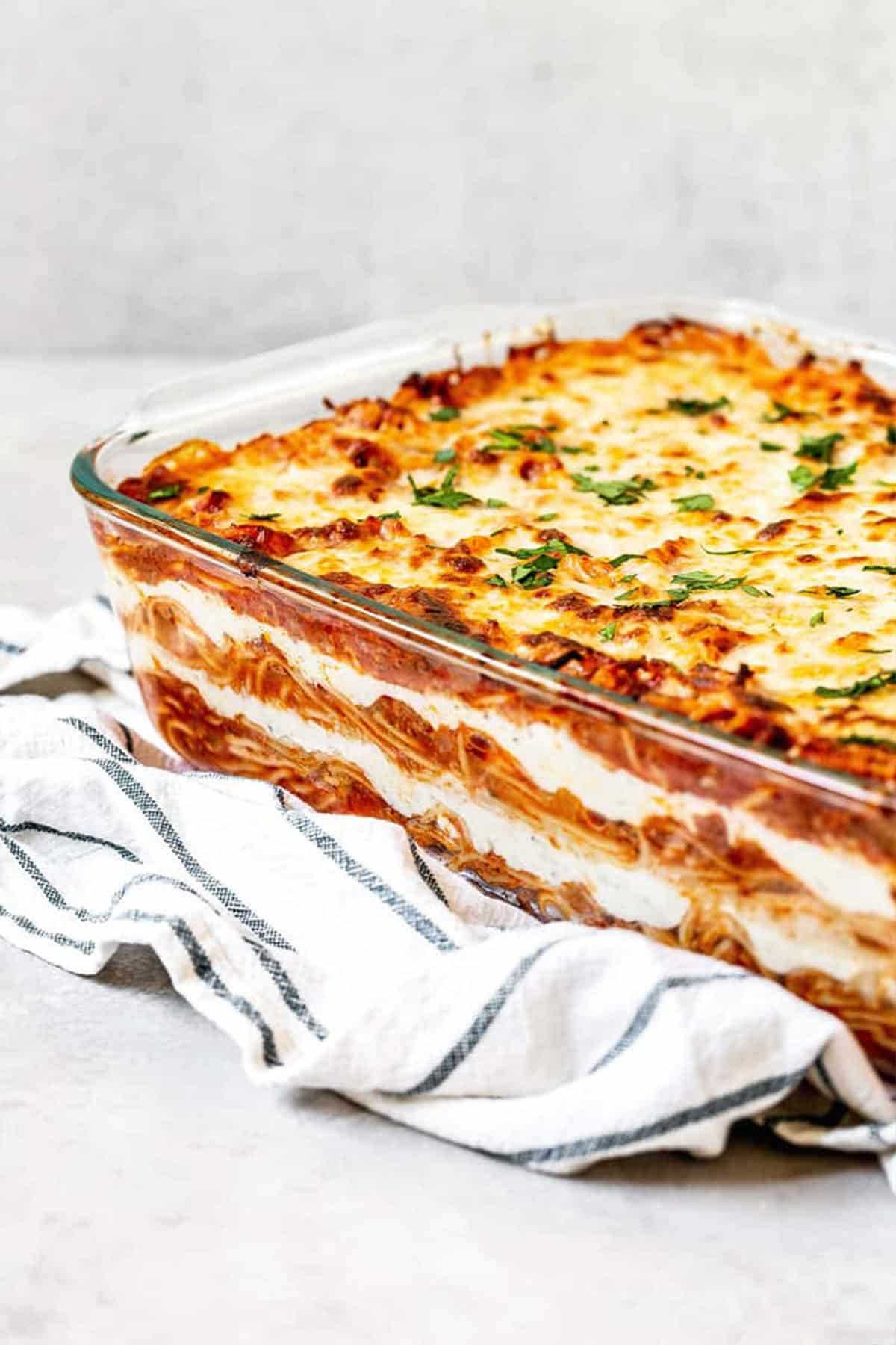 A large Pyrex tray of baked pasta dish with bubbly cheese