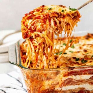 A large spoon lifting Millionaire Baked Spaghetti with delicious layers