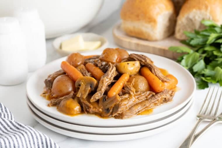A large white plate of pot roast ready to enjoy