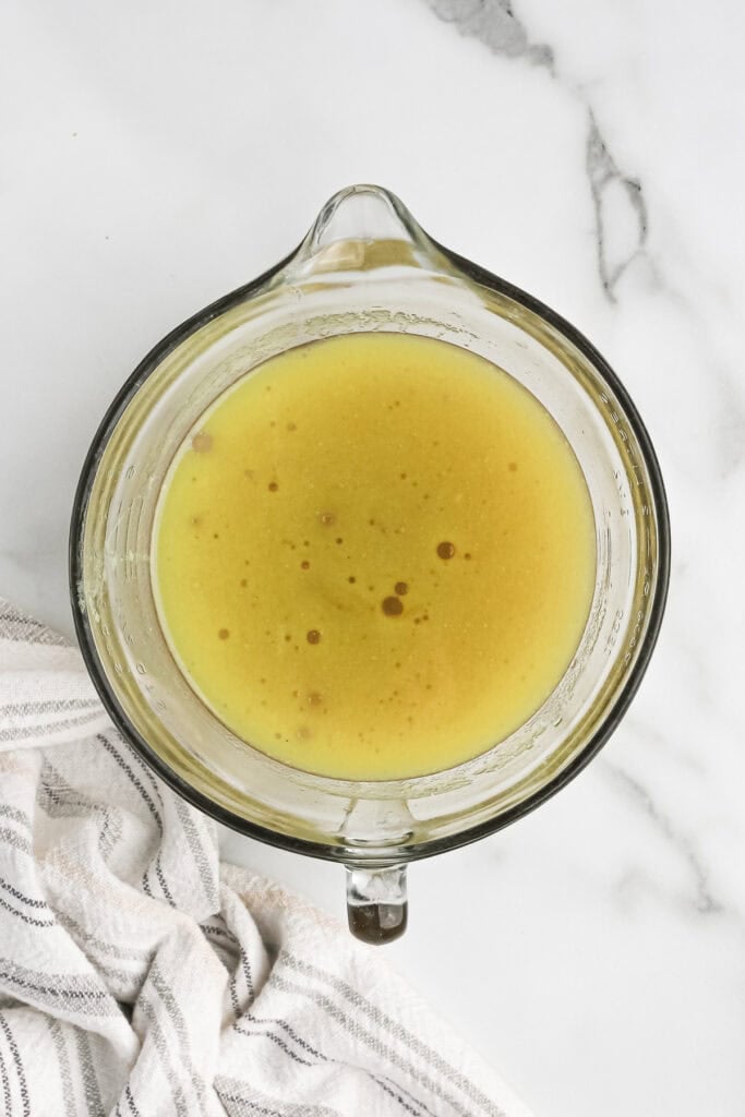 Strained chicken stock in a measuring cup