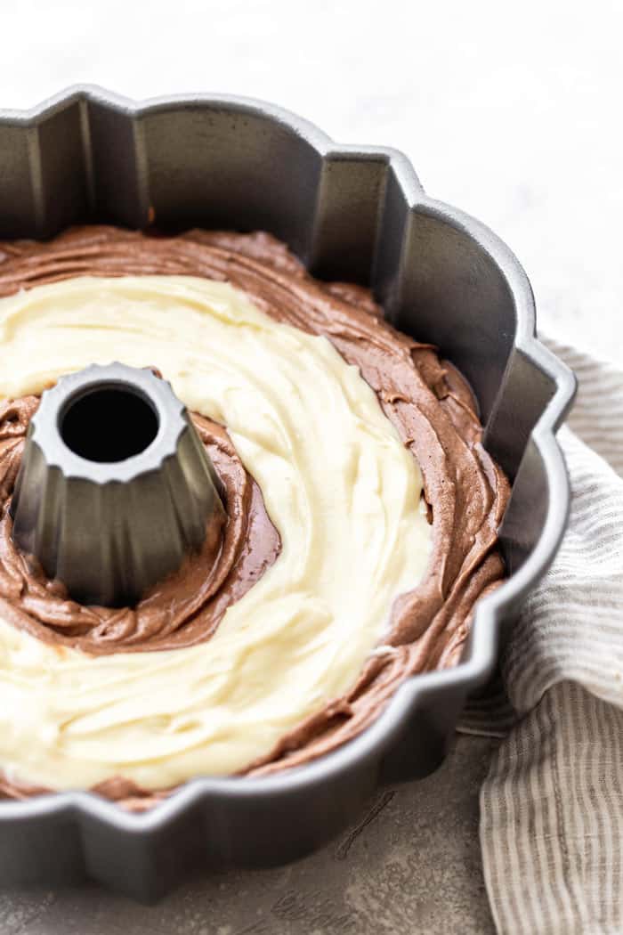 Cream Cheese Filling added to Baileys chocolate bundt cake batter ready to bake in bundt pan