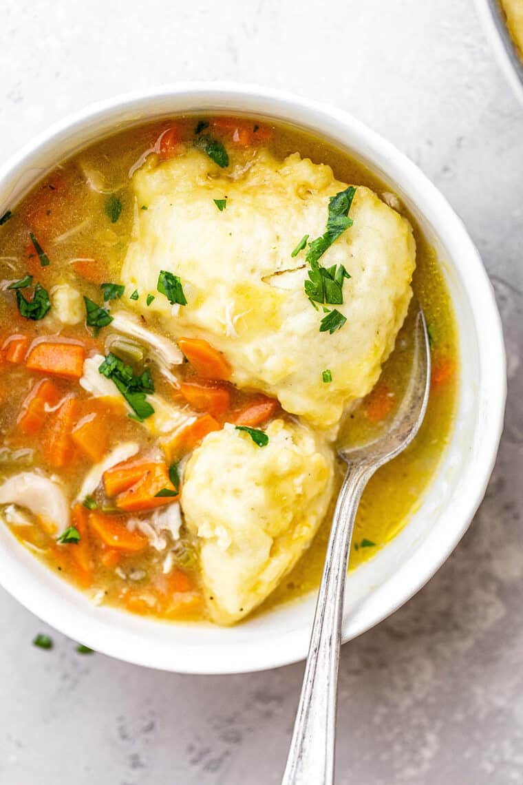 A large bowl of easy chicken and dumplings from scratch with spoon