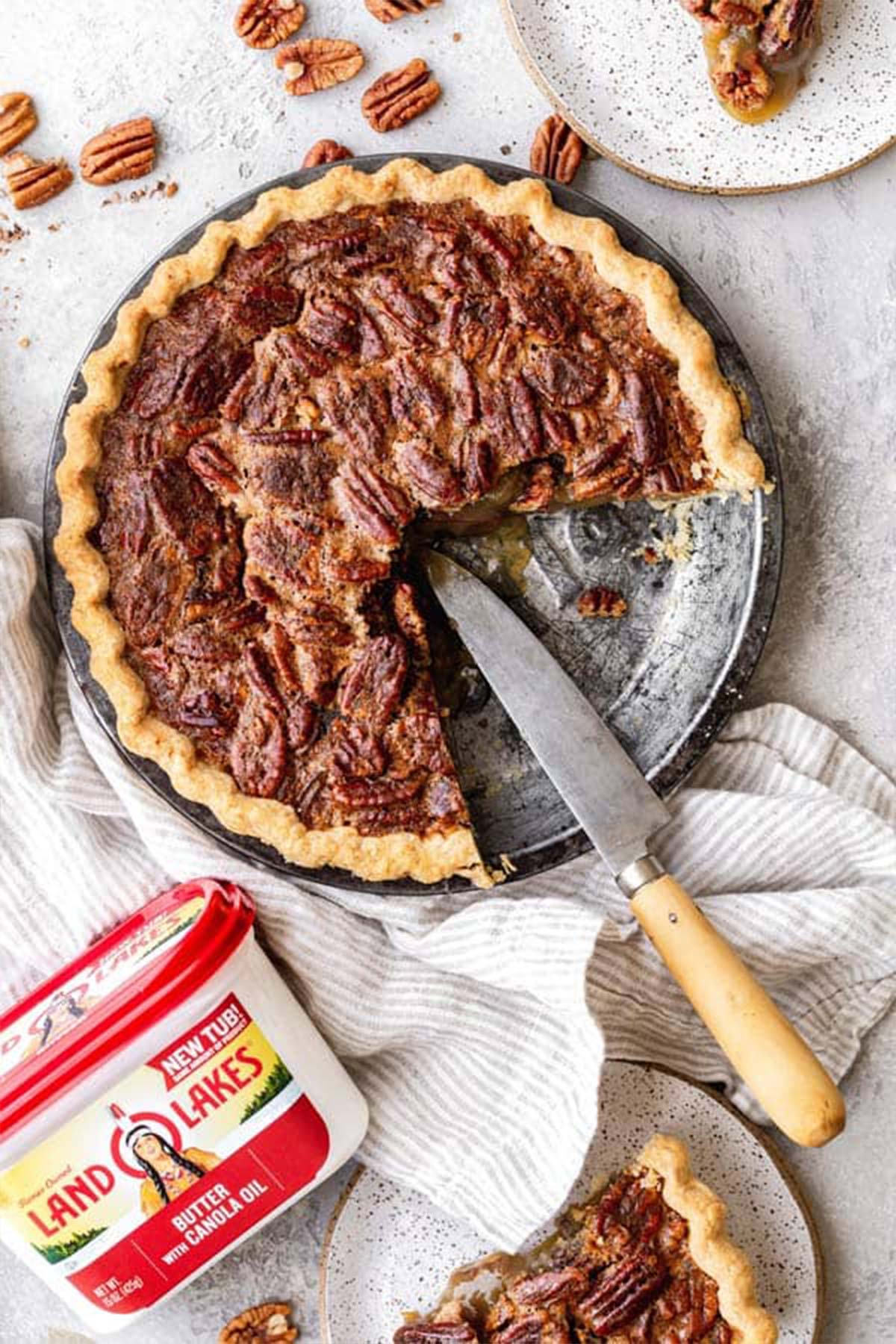 A half pecan pie recipe agains white background with butter