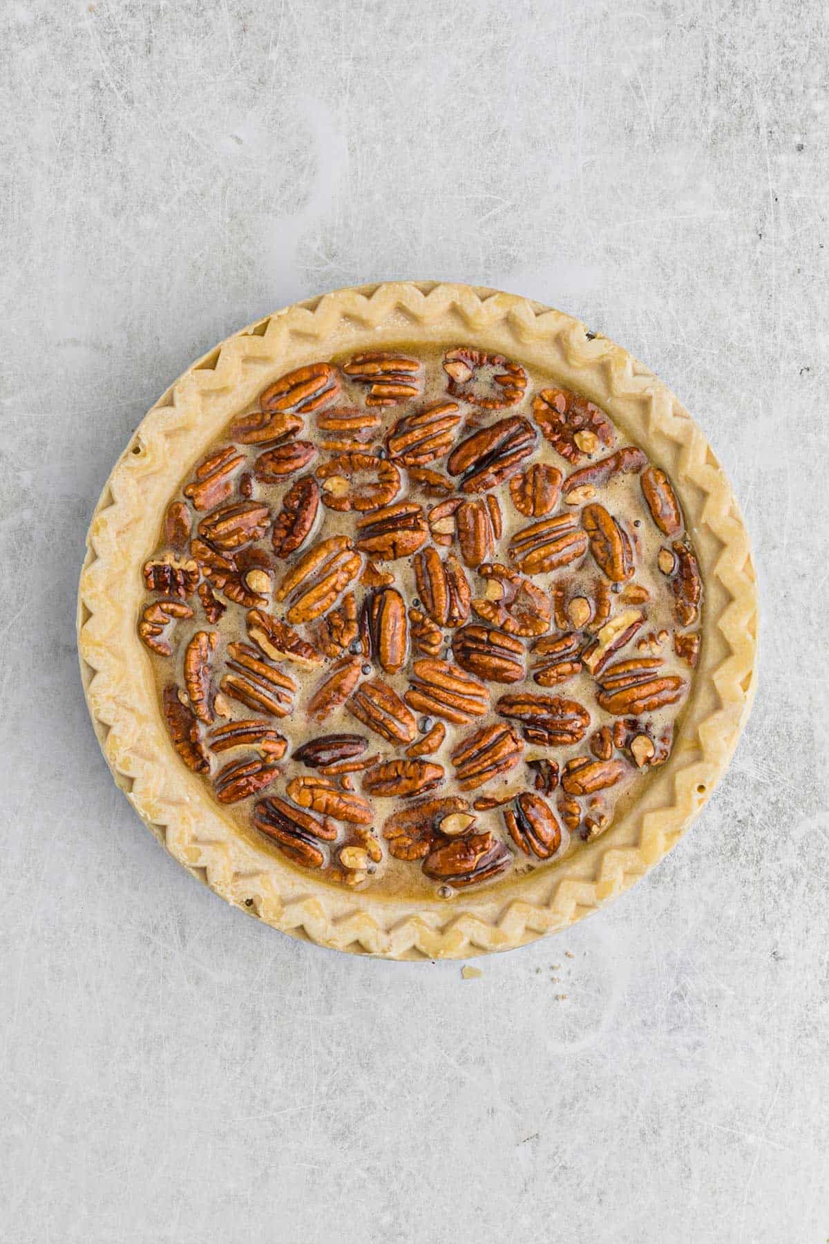 Pecan pie filling poured into an unbaked pie shell.