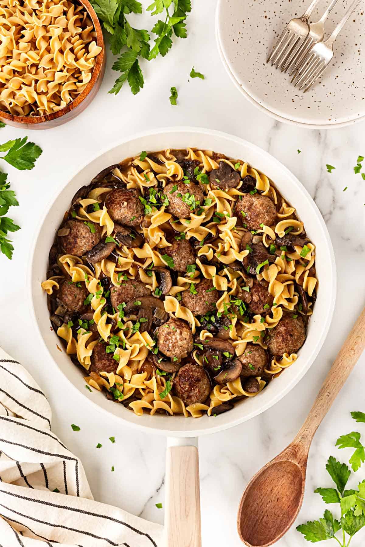 Finished Salisbury steak meatballs and noodles tossed together with mushroom gravy and fresh parsley