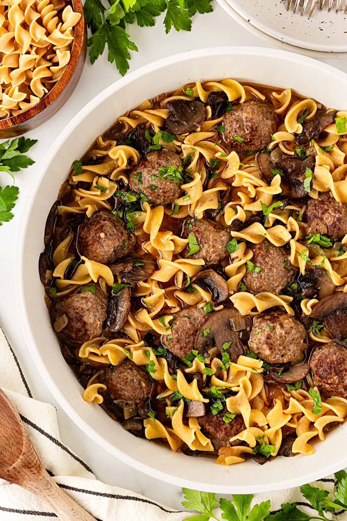 Closeup of Salisbury steak meatballs and egg noodles coated in rich mushroom gravy