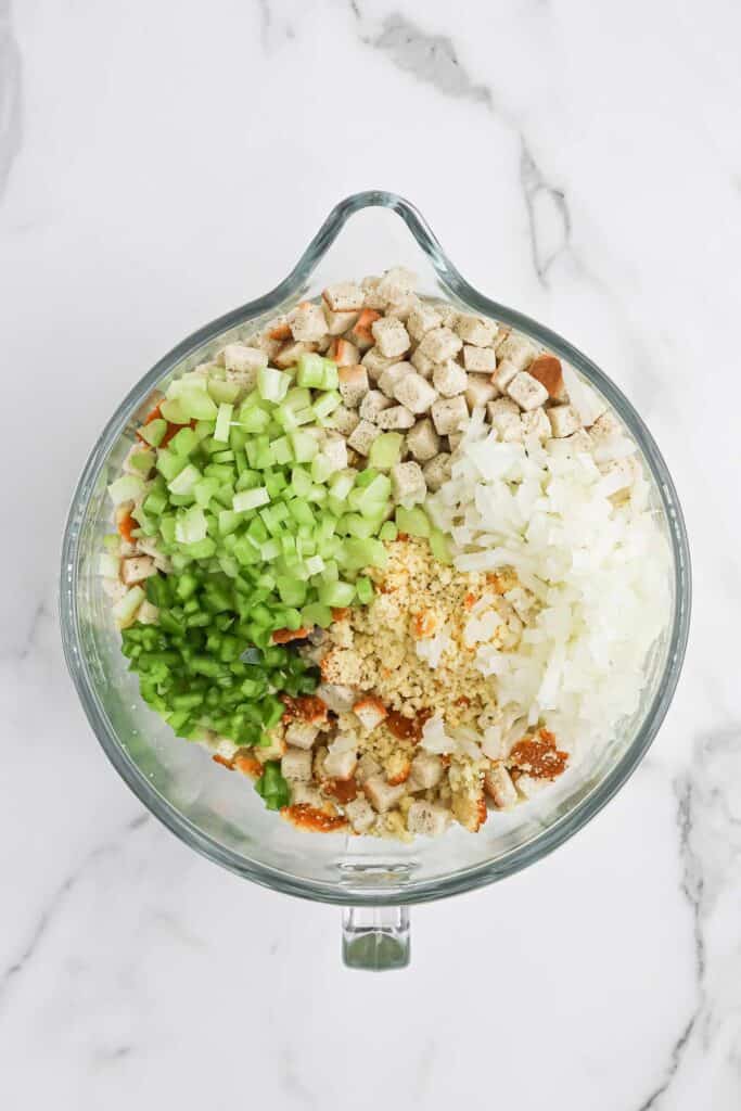 Crumbled cornbread and veggies in a mixing bowl to make Southern dressing.