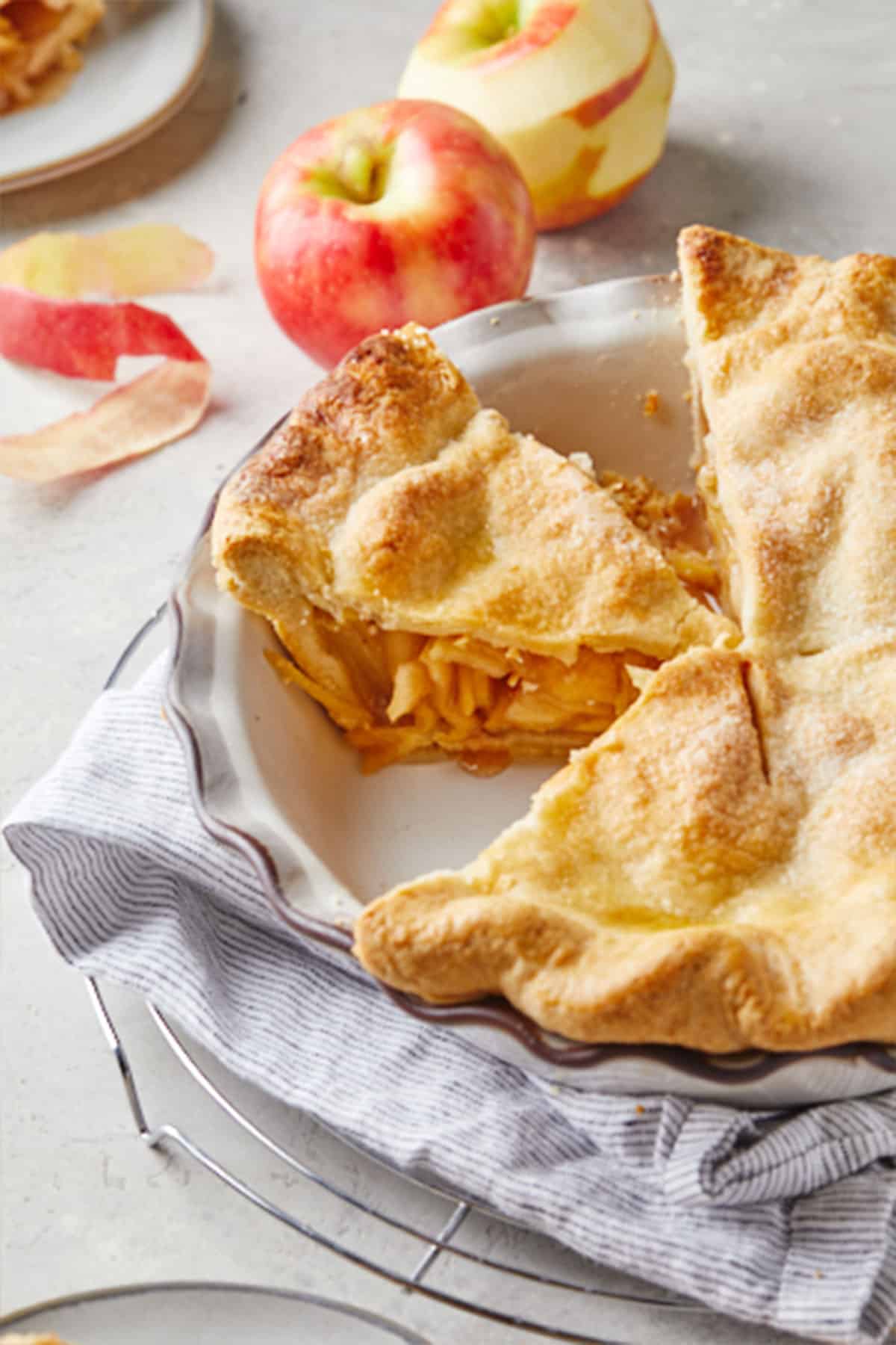 A close up of inside of the best apple pie recipe with peeled apple in the background