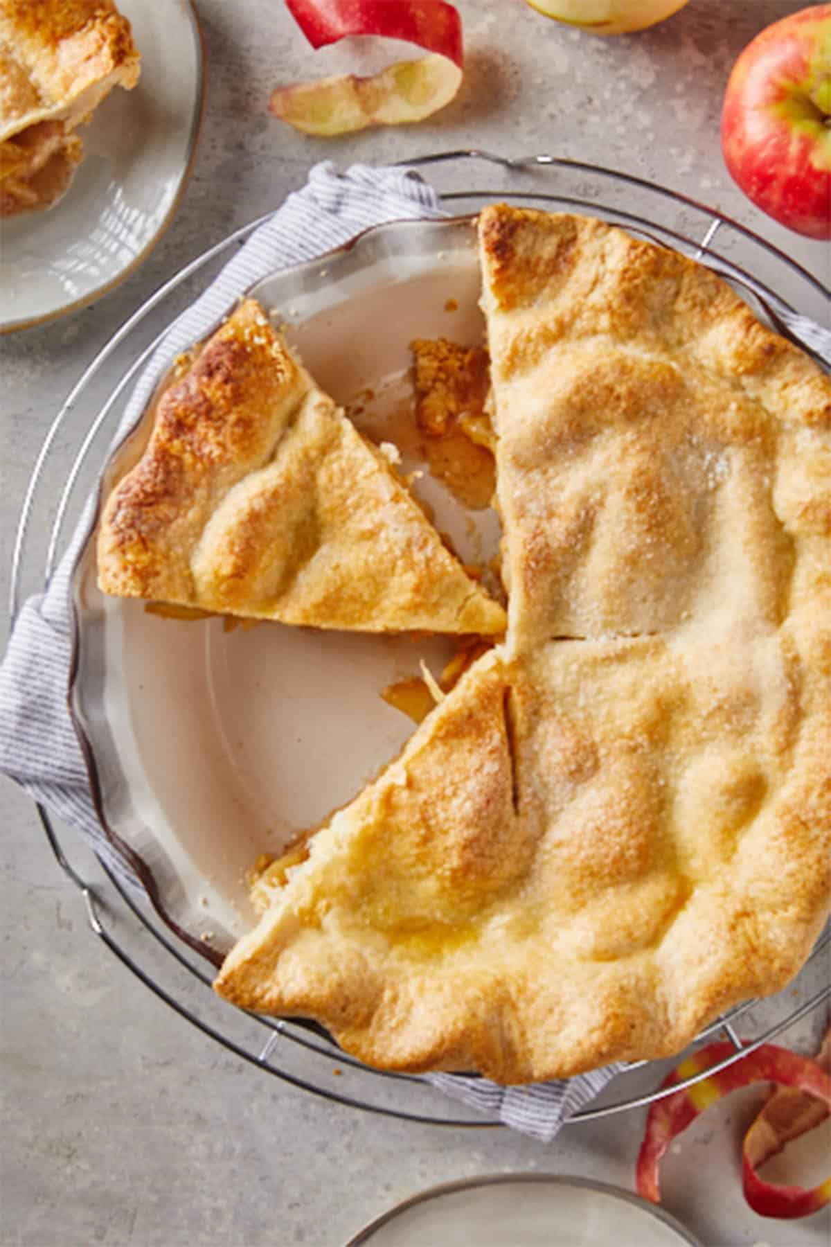 A large apple pie recipe with slices removed ready to serve.