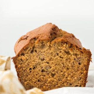An easy banana bread recipe loaf cut open to see the inside on a white background