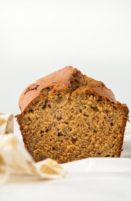 An easy banana bread recipe loaf cut open to see the inside on a white background